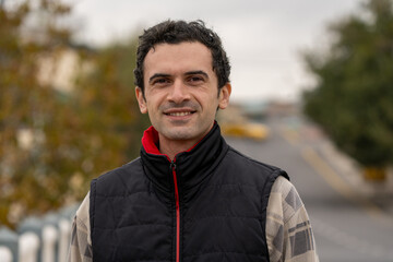 Armenian man, different emotional face actions, in the outdoor, the cold temperature, with the jacket, a little smile on the face