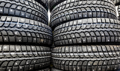 Winter tires stacked up for sale in the superstore - obrazy, fototapety, plakaty