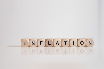 Inflation geschrieben mit Würfeln auf weisser Oberfläche mit Spiegelung.