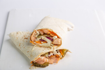 Pita roll with salmon and vegetables filling. Shawarma in pita bread stuffed with vegetables and fish