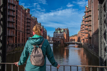 Fototapeta na wymiar A woman enjoys the view in the Speicherstadt in Hamburg