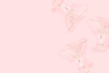 Crystal glasses scattered on a pink background. Creative concept.