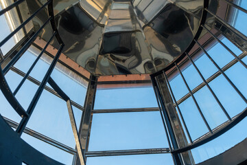Fototapeta premium Interior top of Gavdos Lighthouse, Crete Greece. Metal reflective frame construction and blue sky.