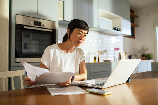 Concerned woman doing home financials in the kitchen
