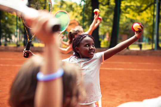 Young girl practicing her server on a outdoor clay tennis court