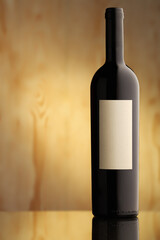 Wine bottle with white blank label and rustic background with copy space. 