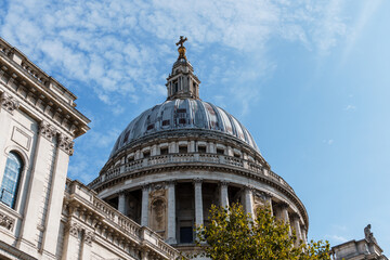 Fototapeta na wymiar Low angle view of the Dome of St Paul Cathedral in London against blue sky