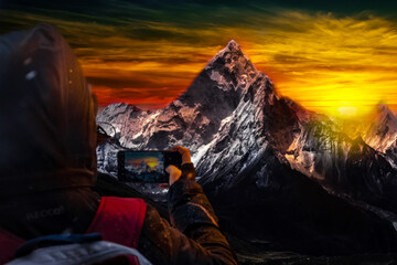 sunset over the mountains, man photographs sunset in the mountains