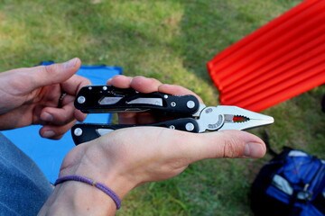 A multitool in the hands of a scout setting up tents during the camp