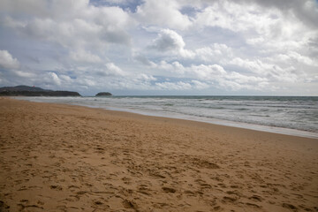 Fototapeta na wymiar Beautiful beach on a cloudy day. Sandy beach. Waves on the sea.