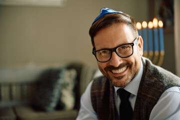 Happy Jewish man at home on Hanukkah looking at camera. - obrazy, fototapety, plakaty