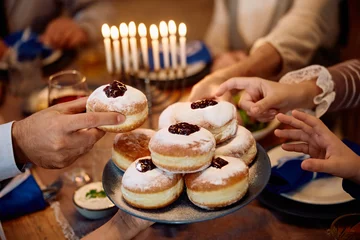 Rolgordijnen Close up of Jewish family having traditional Sufganiyah for dessert on Hanukkah. © Drazen