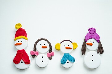 Christmas craft - a family of cute snowmen made from plastic caps and multi-colored plasticine.  Christmas and New Year holiday concept, preparation for the holiday.  New Year card.  Flat laying.