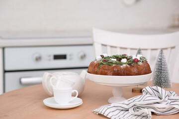 Christmas chocolate bundt cake with fresh berries and rosemary. Winter baking at Christmas or New Year with decorations.Teapot and cups of tea..