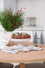 Christmas home interior in white kitchen-Christmas chocolate bundt cake with fresh berries and rosemary. Winter baking at Christmas. Ceramic vase with spruces brunches..