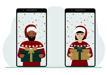 A man and a woman meet online via video conference on mobile phones to discuss Christmas and New Year holidays and gifts virtually.
