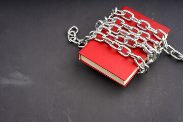 the red book is wrapped with a steel chain on a gray background