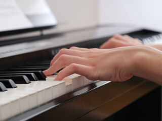 A young man playing on a digital piano