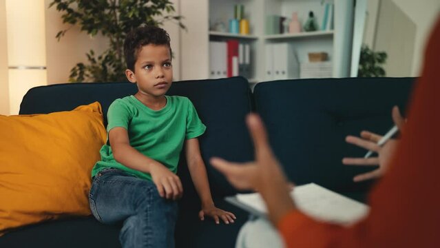 Little boy talking to a woman child counsellor, professional therapy for kids. Child therapy, youth counselling