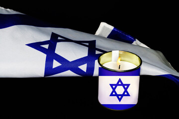 Israel Flag and memorial candle depicting the Israeli Flag. Composition for October 7, 2023 -...