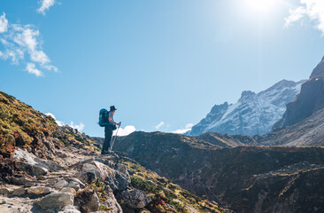 Young hiker backpacker man enjoying valley view in Makalu Barun Park route near Khare during high altitude acclimatization walk. Mera peak trekking route, Nepal. Active vacation concept image