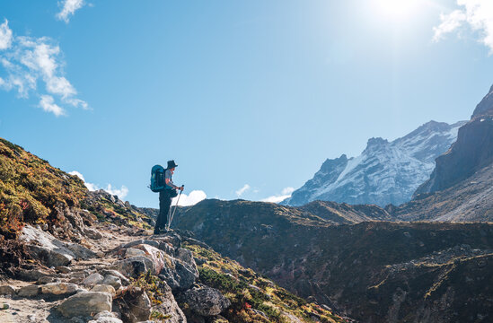Young hiker backpacker man enjoying valley view in Makalu Barun Park route near Khare during high altitude acclimatization walk. Mera peak trekking route, Nepal. Active vacation concept image