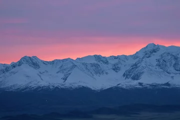  Soft pink light glides over the snow-capped peaks of the mountains in the early morning. Beautiful mountain landscape of the North Chui ridge, with snow-capped mountain peaks, beautiful pink glow. © sablinstanislav