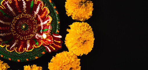 Diwali's radiance shines through, A stunning Diwali lamp and intricate flower rangoli on a...