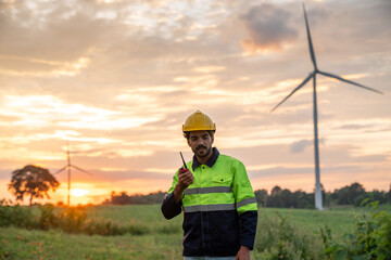 Service engineers checking system of windmill with tablet. Wind turbines generate electricity. Clean and Renewable energy concept.