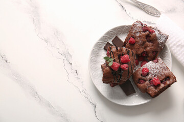 Plate with pieces of raspberry chocolate brownie on white background