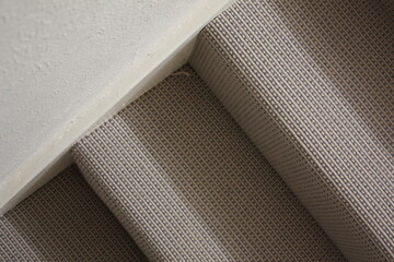 Fototapeta na wymiar Overhead shot of brown and grey patterned carpet on stairwell