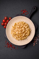 Raw Italian pasta conchiglie from durum wheat with vegetables, salt and spices