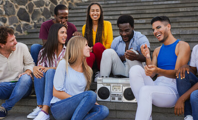 Group of multiracial young friends having fun together in the city while listening music from...