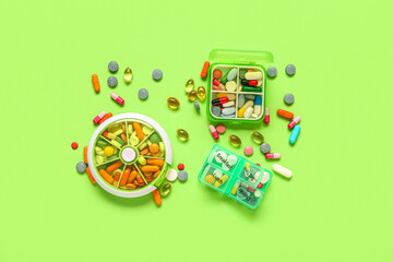 Containers with different pills on green background