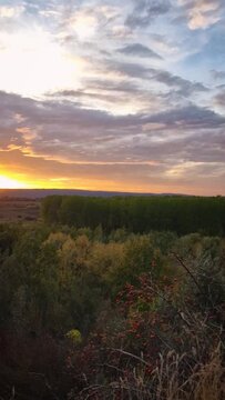 Autumn evening over the valley. Beautiful view to the multicolored forest and orange october sunset. Picturesque fall season scenery