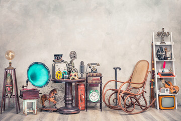 Antique gramophone, rocking chair, vintage movie projector, tape recorder, mic, film camera, mask, telephone, clock, books, fiddle, old typewriter, radio, TV, candlestick. Retro style filtered photo - obrazy, fototapety, plakaty