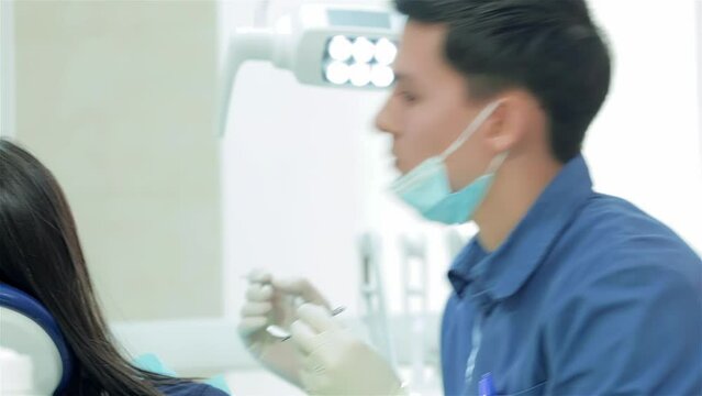 The dentist selects the tool and starts examination of the teeth