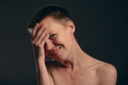 Capturing the essence of self-care, this image showcases a middle-aged lady with a trendy short hairstyle, delicately exposing her bare shoulders, all  