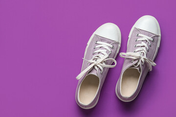 Stylish sneakers on purple background