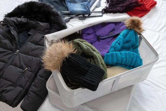 Horizontal photo, collecting winter clothes on a bed. Lifestyle concept.