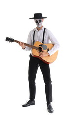 Young man with painted skull playing guitar on white background. Mexico's Day of the Dead (El Dia de Muertos) celebration