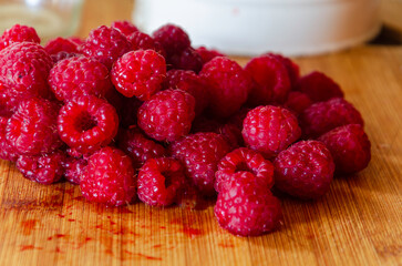 Red raspberries on a wooden board ready for making jam