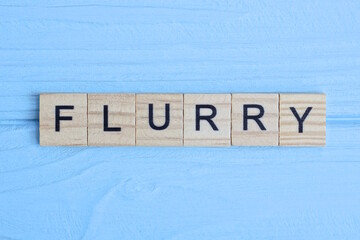 word flurry made from wooden gray letters lies on a blue background