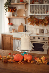 Halloween cake idea. Cake with spider webs and skulls. The kitchen is decorated for autumn