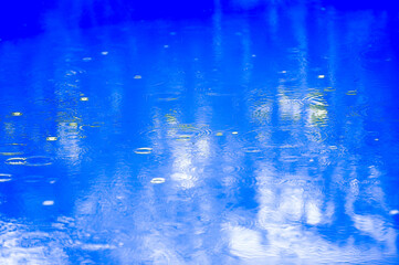 Tafla wody w basenie krople deszczu. © Monika
