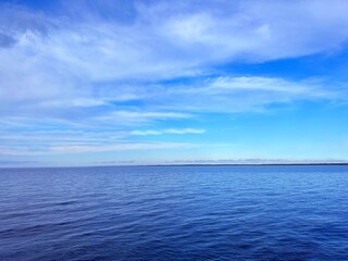 Blue sea water, sky, clouds, horizon.