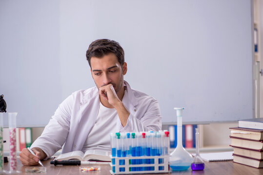 Young male chemist in front of white board - Powered by Adobe