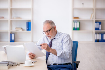 Old male employee working in the office