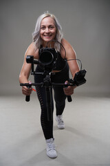 Naklejka premium Woman videographer with gimbal and camera