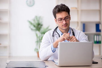 Young male doctor suggesting pills in the clinic